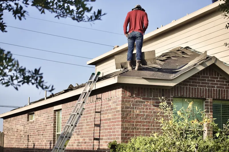 Professional roofer working on a residential roof in Pershing Place